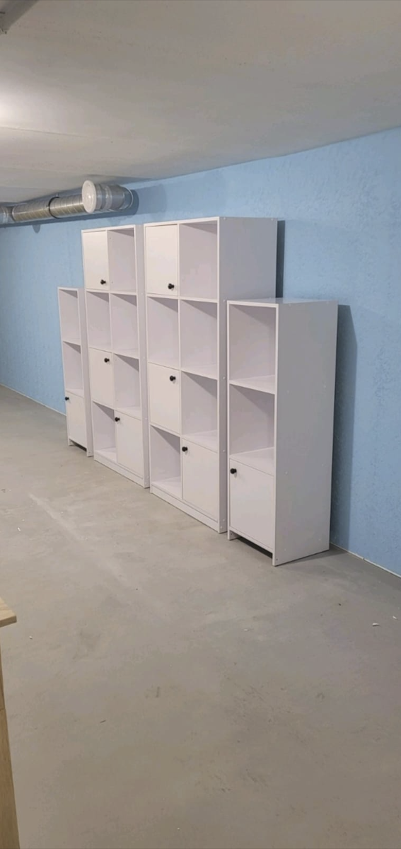 White storage cubbies lining a wall of the underground room.